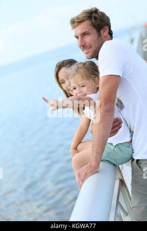 Familie, die auf einem Ponton mit Blick auf das Meer Stockfoto