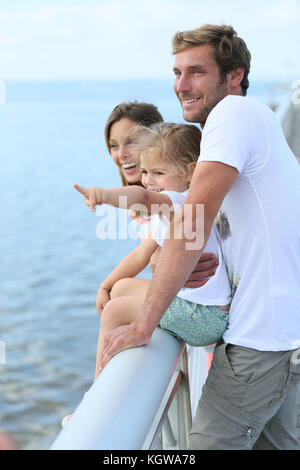 Familie, die auf einem Ponton mit Blick auf das Meer Stockfoto