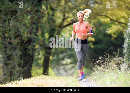 Schöne athletische Frau im Wald laufen Stockfoto