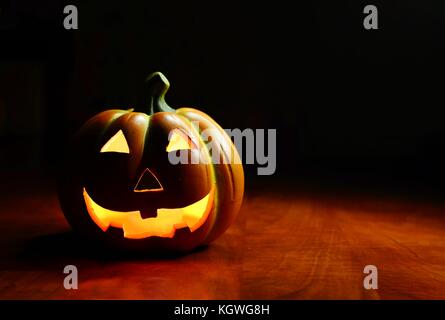 Beleuchtete lächelnd Spooky Halloween Kürbis auf einem dunklen Hintergrund. Stockfoto