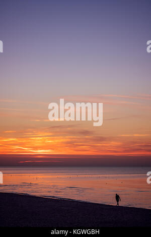 Nicht identifizierte einsamer Mann auf dem Meer Strand im Sommer bei Sonnenuntergang Stockfoto