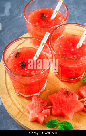 Wassermelone Smoothies in Gläser mit Minze auf einem grauen dunklen konkreten Hintergrund Stockfoto