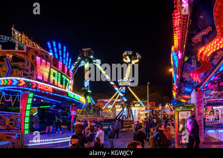 Menschen und Fahrgeschäfte in der Nacht, Goose Fair, Nottingham, England, Großbritannien Stockfoto