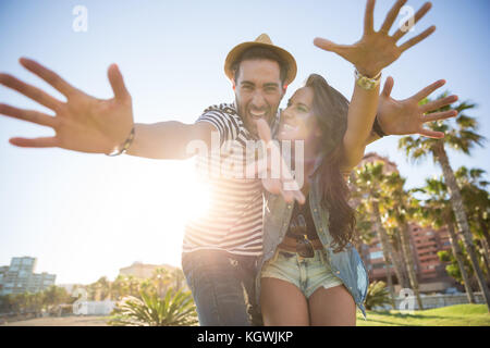 Portrait von glückliches Paar heben die Hände im Sonnenlicht Spaß Stockfoto