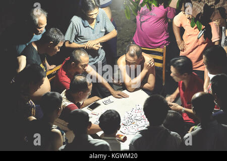 Guilin, China - 15. September 2017: Männer spielen Karten in einem Park bei Nacht. Stockfoto