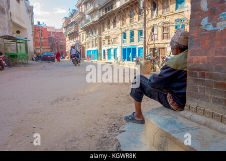 Kathmandu, Nepal Oktober 15, 2017: unbekannter Mann an draußen sitzen in einer Stadt mit sehr alten und beschädigten Gebäude nach dem Erdbeben in 2015 der Durbar Square in Kathmandu, der Hauptstadt von Nepal Stockfoto