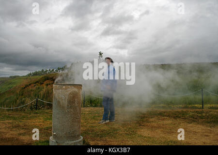 Frau, die in Dampf stieg aus heißem Thermalwasser in der vulkanischen Landschaft Stockfoto