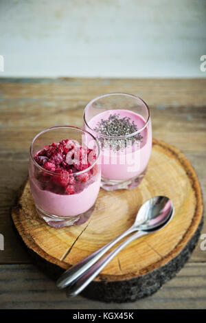 Chia und gefrorene raspberies Hüttenkäse Frühstück in zwei kleinen transparenten Gläser Stockfoto