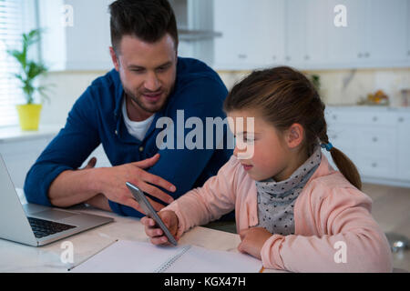 Vater und über Handy an tabe Tochter Stockfoto
