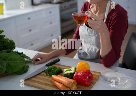 Den mittleren Abschnitt der Frau mit Zitrone Kaffee am Tisch in der Küche Stockfoto