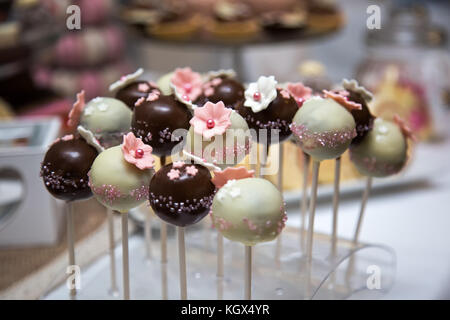 Schokolade Kuchen Pop in Milch und weiße Schokolade mit rosa essbare Marzipan Blumen bedeckt Stockfoto