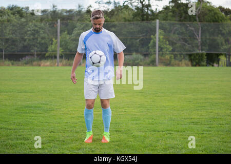 Fußball-Spieler jonglieren Fußball im Boden Stockfoto