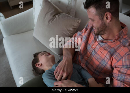 Vater kitzeln sein Sohn im Wohnzimmer zu Hause Stockfoto