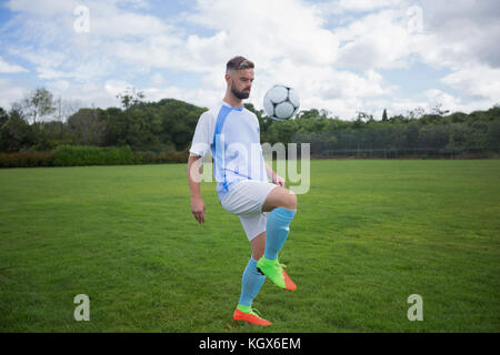 Fußball-Spieler jonglieren Fußball im Boden Stockfoto