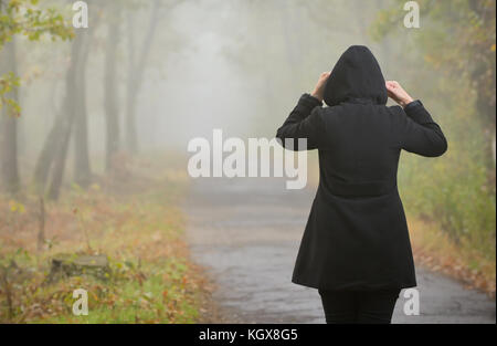 Frau in einer nebligen Wald im Herbst Stockfoto