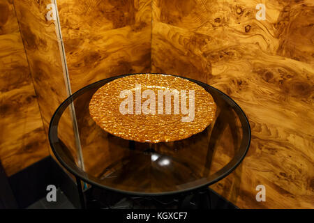 Die goldene Platte auf dem transparenten Glas Tisch Stockfoto