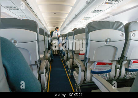 Stewardess bietet Speisen und Getränke in der Economy Class Passagiere Stockfoto