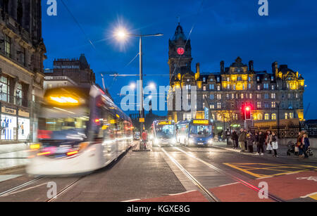 Nachtansicht der Princes Street in Edinburgh mit der Edinburgh Straßenbahn und dem Verkehr auf Langzeitbelichtung in Schottland, Großbritannien. Stockfoto