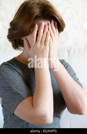 Frau, die ihr Gesicht mit der Hand. Depression Stockfoto