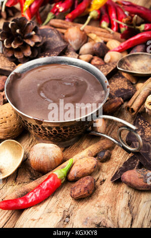 Schale mit geschmolzener Schokolade, Kakao, Nüssen und Gewürzen Stockfoto