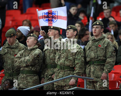 Ein Mitglied der Streitkräfte schwenkt während des Internationalen Freundschaftsspiel im Wembley Stadium, London, eine St. Georges-Flagge mit drei Löwen. Stockfoto