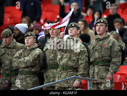 Ein Mitglied der Streitkräfte schwenkt während des Internationalen Freundschaftsspiel im Wembley Stadium, London, eine St. Georges-Flagge mit drei Löwen. Stockfoto