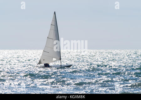 Segelboot Segeln auf einem glitzernden Meer in einem windigen sonnigen Tag Stockfoto