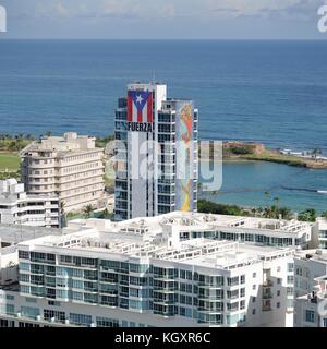 Ein großes Banner mit der Flagge Puerto Ricas und dem spanischen Wort für Stärke zieren das Bürogebäude El Caribe während der Hilfsmaßnahmen nach dem Hurrikan Maria vom 6. November 2017 in San Juan, Puerto Rico. (Foto von Steven Shepard über Planetpix) Stockfoto