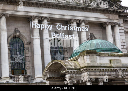 Vor der City Hall von Belfast, in dem die Zeichen Frohe Weihnachten Belfast über dem Haupteingang. Stockfoto