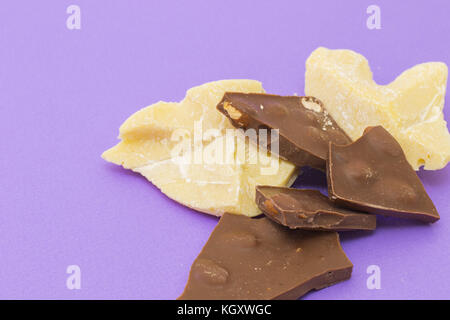 Milchschokolade mit Mandeln und Kakao Butter auf violette Hintergrund Stockfoto
