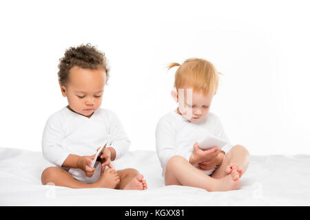 Multikulturelle Kleinkinder mit digitalen Smartphones Stockfoto