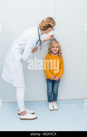 Arzt Messhöhe von kleines Mädchen Stockfoto