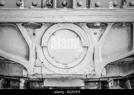 Grau lackiert solide Metallrahmen mit Schrauben und eine große in der Mitte der Vorderachse. schwarz-weiß-Bild. Stockfoto