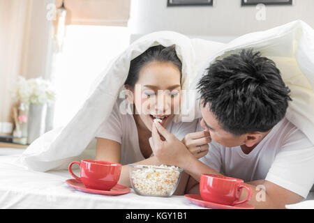 Junge asiatische Paare mit Frühstück am Bett im Schlafzimmer der zeitgenössischen Haus für modernen Lifestyle Konzept Stockfoto