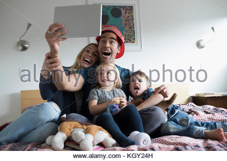 Junge Familie selfie mit digitalen Tablet auf dem Bett