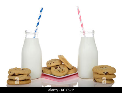 Chocolate Chip Cookies auf eine Quadratische weiße Platte mit rosa Serviette unterhalb, Flasche Gläser Milch auf jeder Seite mit junge Mädchen Trinkhalme Blau und Rosa, st Stockfoto