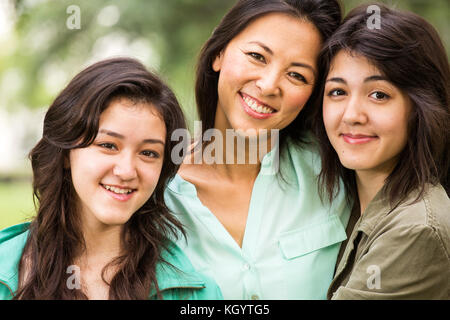 Asiatische Mutter Lachen und huging ihren Töchtern. Stockfoto