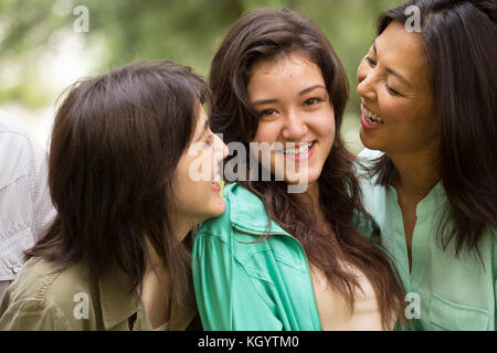 Asiatische Mutter Lachen und huging ihren Töchtern. Stockfoto