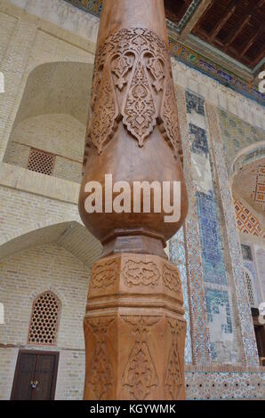 Slim aus Holz geschnitzte Säulen der bolo hauz Moschee in Buchara, Usbekistan. Stockfoto