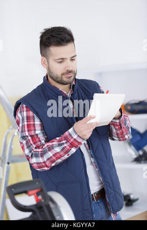 Arbeitnehmer Überprüfung seiner Liste in ein großes Lager Stockfoto