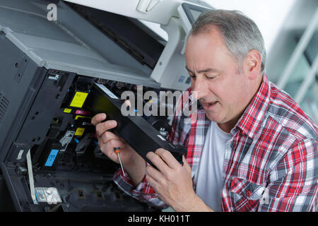 Mann bei der Arbeit an professionellen Drucker Stockfoto