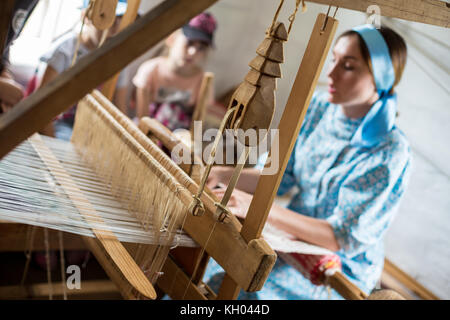 Die Frau ist das Weben der bunte Baumwolle Bademantel oder Kleid durch die Verwendung von Holz- Webstuhl im Dorf in Russland Stockfoto