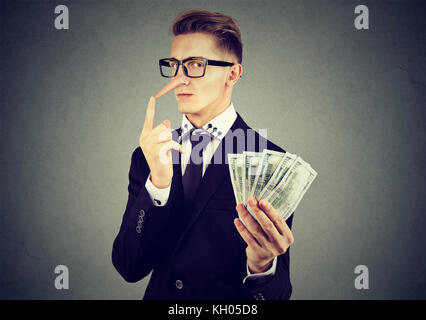 Finanzbetrug Konzept. Lügner junge Geschäftsmann in Anzug und Brille mit Dollar cash Stockfoto