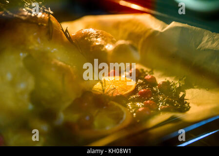 Appetitlich Brathähnchen Türkei mit Orangenscheiben Preiselbeeren und Kräutern im Ofen. Stockfoto