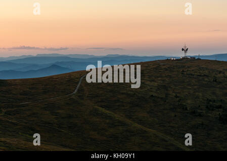 Malerische Aussicht mit dem Repeater und Telekommunikation Turm auf einem Berg Weg und Bäume bei Sonnenuntergang Stockfoto