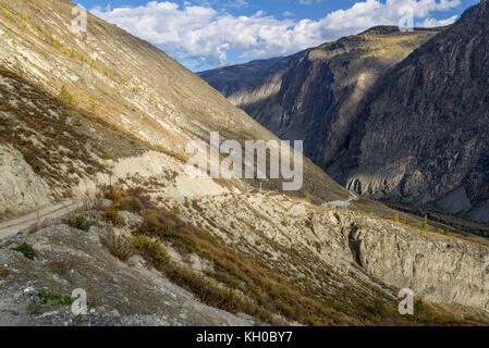 Malerischer Blick auf steile kurvenreiche Kies Berg Straße durch den Pass, Teil des Berges Serpentine, vorbei an den Hang des Berges auf einem Hintergrund Stockfoto