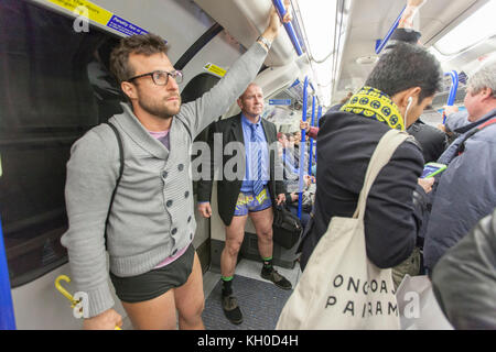 Viele der Passagiere, die in der Londoner U-Bahn hatte eine Überraschung und ein gutes Lachen, wenn eine große Gruppe von Menschen ohne Hose das Rohr eingetragen am "no pants Subway ride" im Jahr 2016. Stockfoto