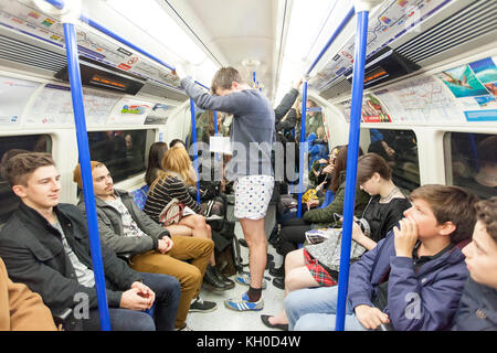 Viele der Passagiere in der Londoner U-Bahn hatten eine Überraschung und ein gutes Lachen, als eine große Gruppe von Leuten ohne Hose beim „No Pants Subway Ride“ 2016 in die U-Bahn kam. Stockfoto