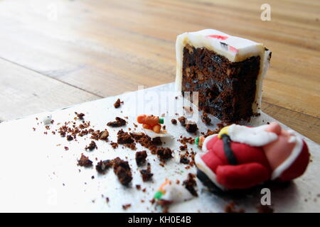 Das letzte Stück von einem hausgemachten Weihnachtskuchen, mit einem Eingestürzten sugarcraft Weihnachtsmann, oder Santa Claus, von Vereisung oder Fondant. Kopieren Sie Platz Stockfoto