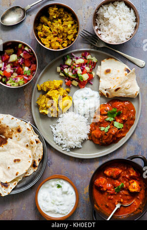 Indisches essen mit Chicken Tikka Masala, Aloo Gobi, Salat, Reis und Brot Stockfoto